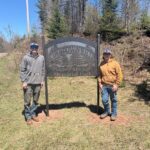 Students standing by Ely Township Memorial Park Sign